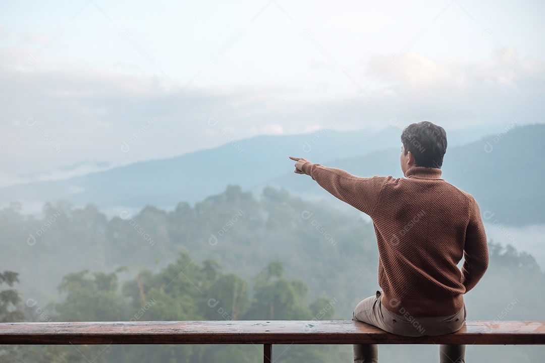 Homem turista feliz relaxando e olhando a vista para a montanha no país.