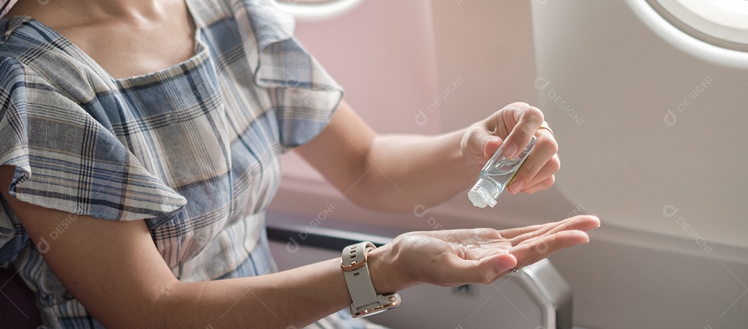 Mão limpa de mulher por desinfetante de gel de álcool em avião ou público.