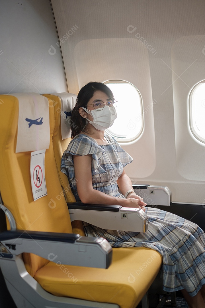 Mulher usando máscara facial protetora sentada em avião ou público.