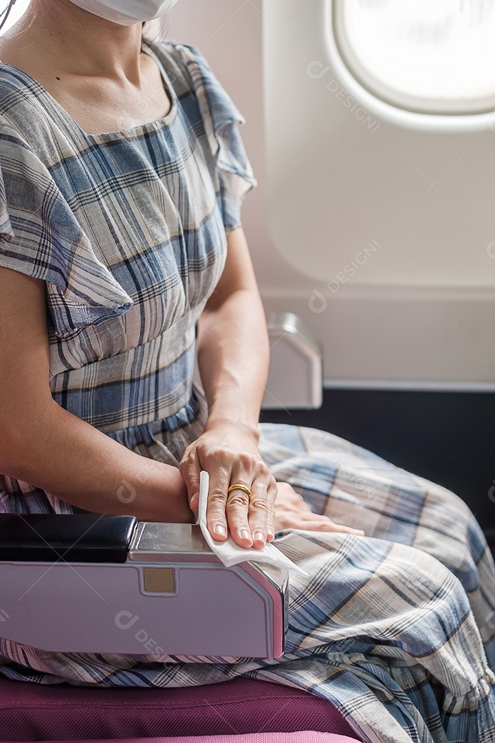 Assento limpo de mulher com lenço umedecido em avião ou transporte público.