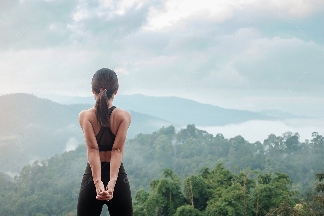 Fêmea jovem fitness em roupas esportivas esticando o corpo contra a montagem.