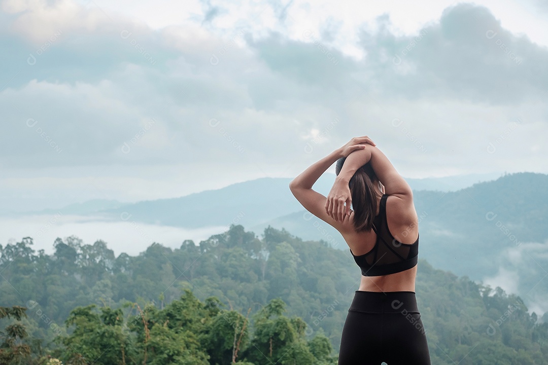 Fêmea jovem fitness em roupas esportivas esticando o corpo contra a montagem.