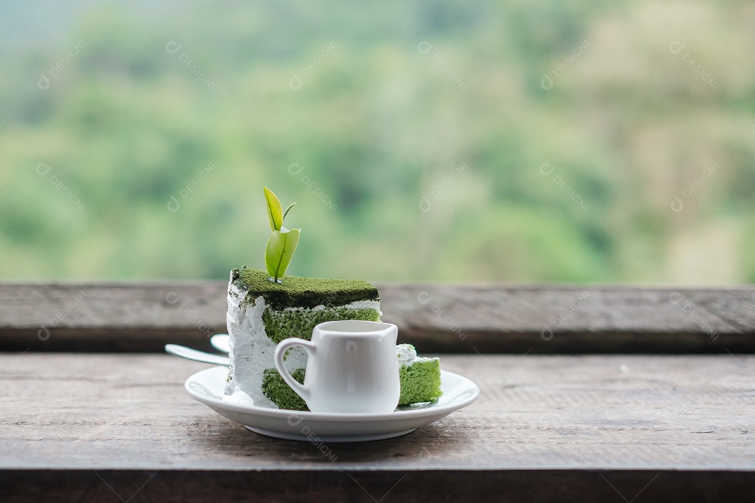 Bolo de chá verde com folha de chá de broto jovem na mesa de madeira contra