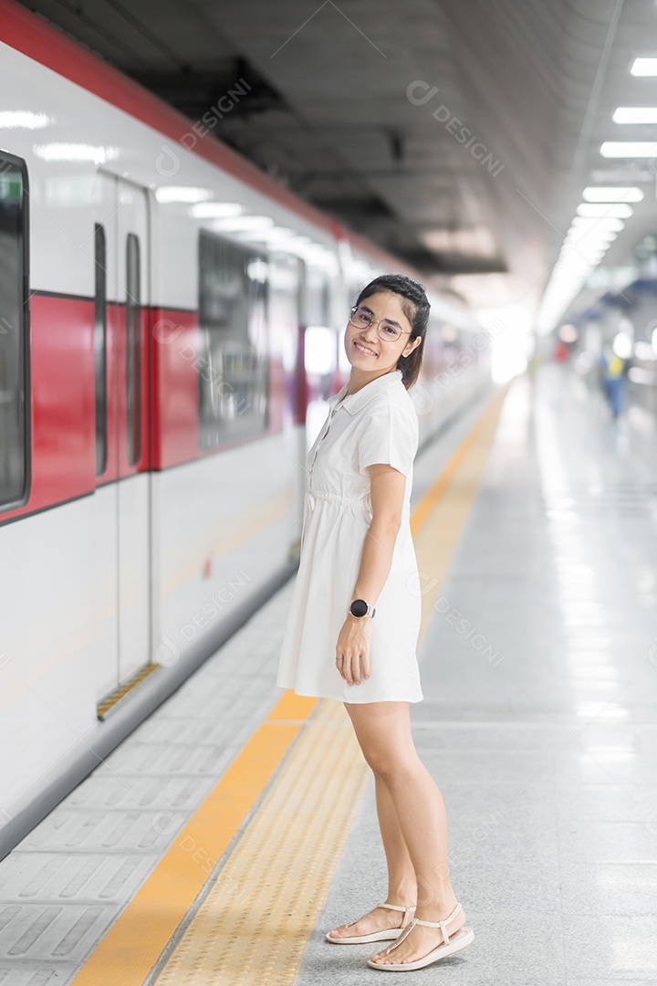 Mulher feliz esperando trem na estação de transporte público