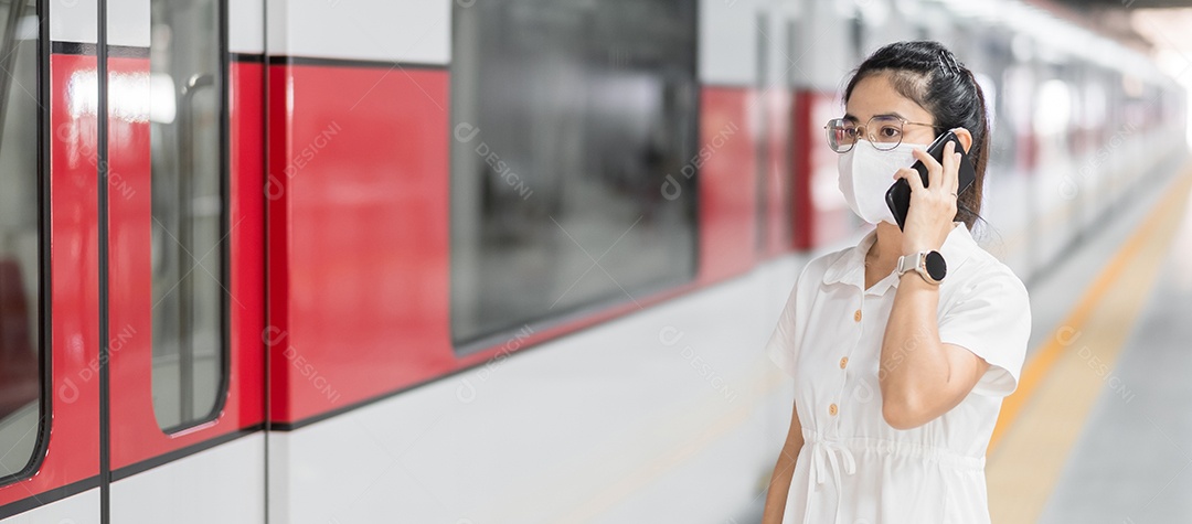 mulher usando smartphone durante o uso de máscara facial protetora