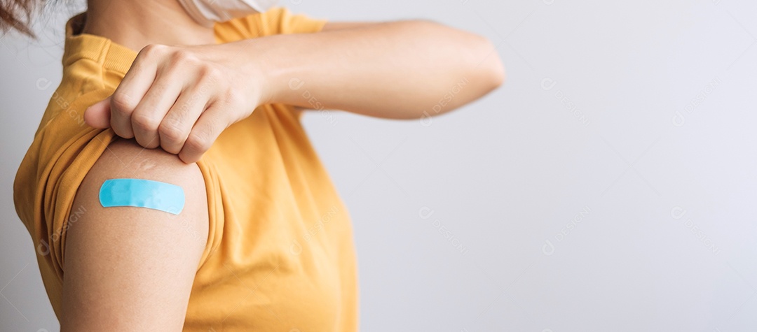 mulher mostrando curativo após receber a vacina covid 19. Vacinação