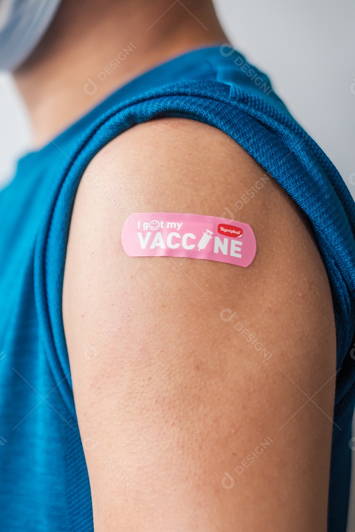 homem mostrando curativo após receber a vacina covid 19. Vacinação