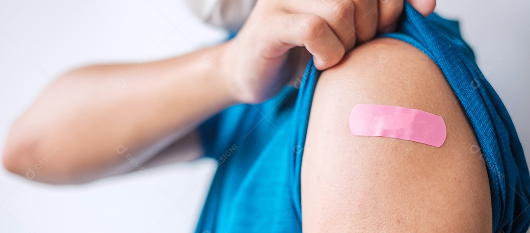 homem mostrando curativo após receber a vacina covid 19. Vacinação