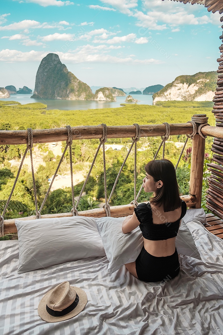 A mulher viajante feliz aprecia o ponto de vista da baía.