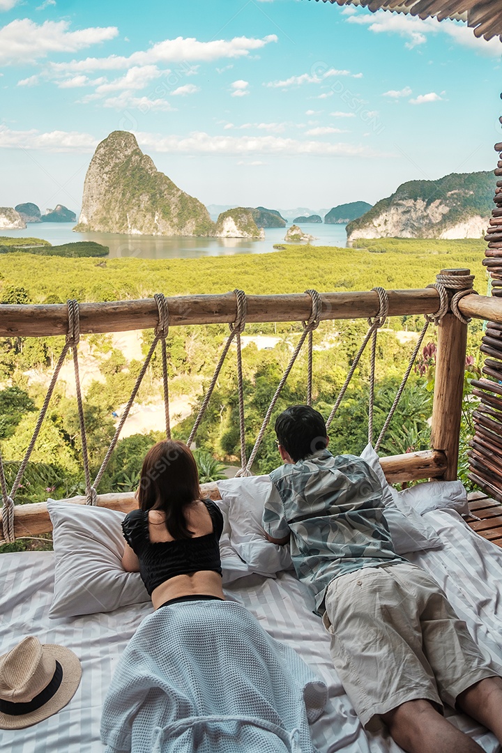 O viajante feliz do casal aprecia o ponto de vista da baía.