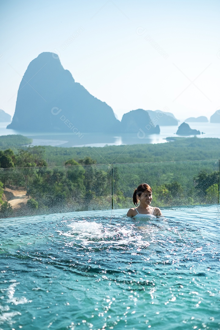 Mulher feliz em maiô branco nadando na piscina de luxo hotel.