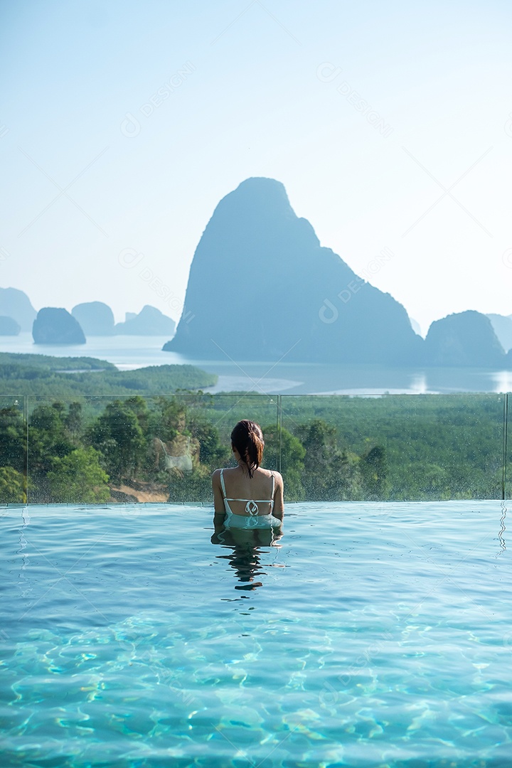 Mulher feliz em maiô branco nadando na piscina de luxo hotel.