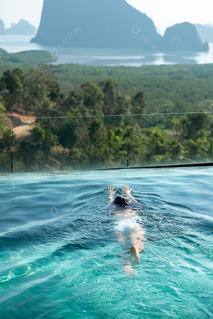 Mulher feliz em maiô branco nadando na piscina de luxo hotel.