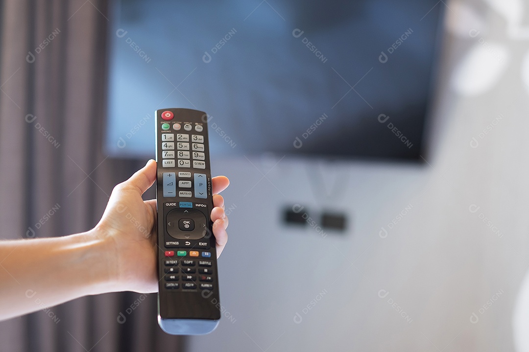 Mão usando o controle remoto para ajustar a TV dentro do modo.