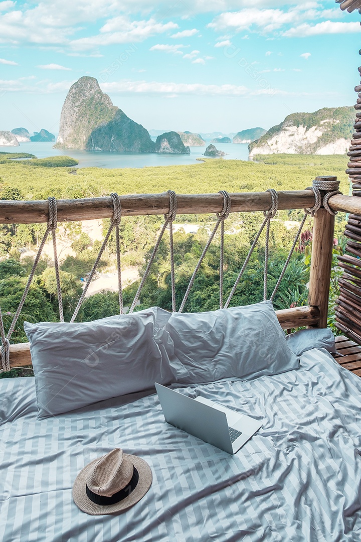 Laptop e chapéu contra o fundo da baía de turistas.