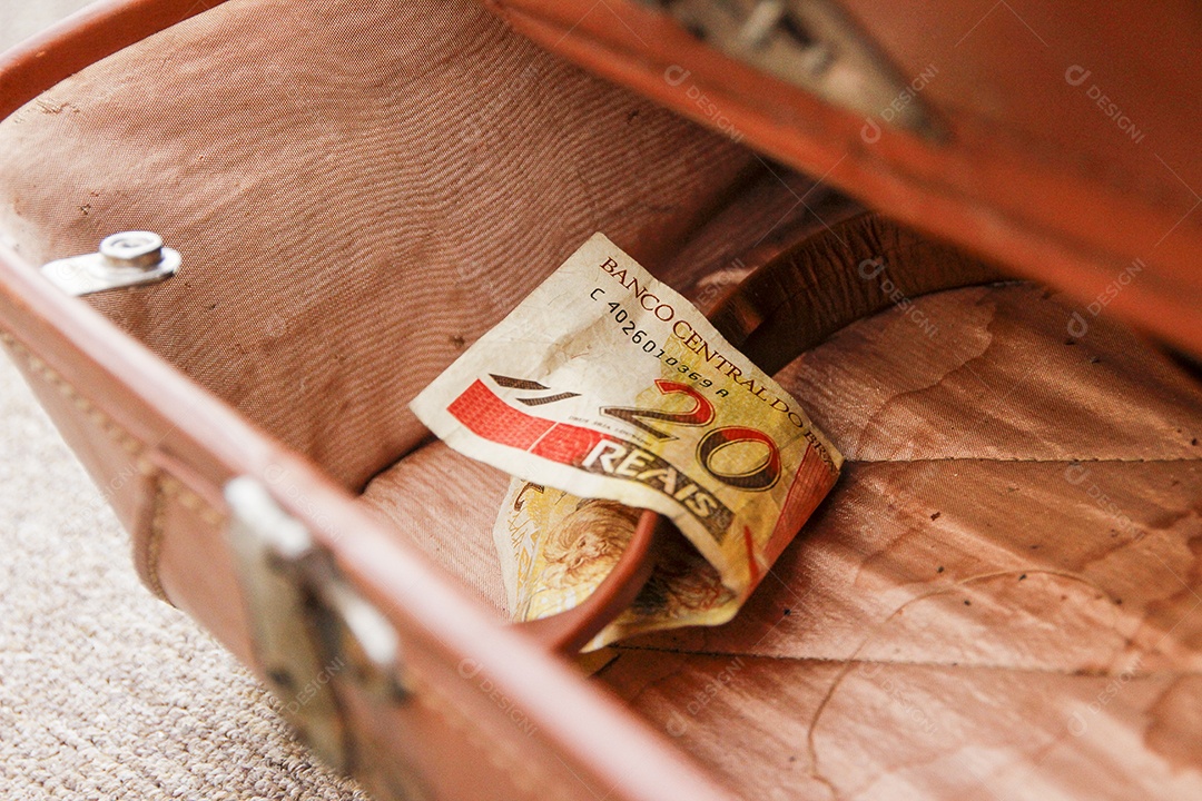 nota de vinte reais (moeda brasileira), jogada dentro de uma velha bolsa marrom no Rio de Janeiro.