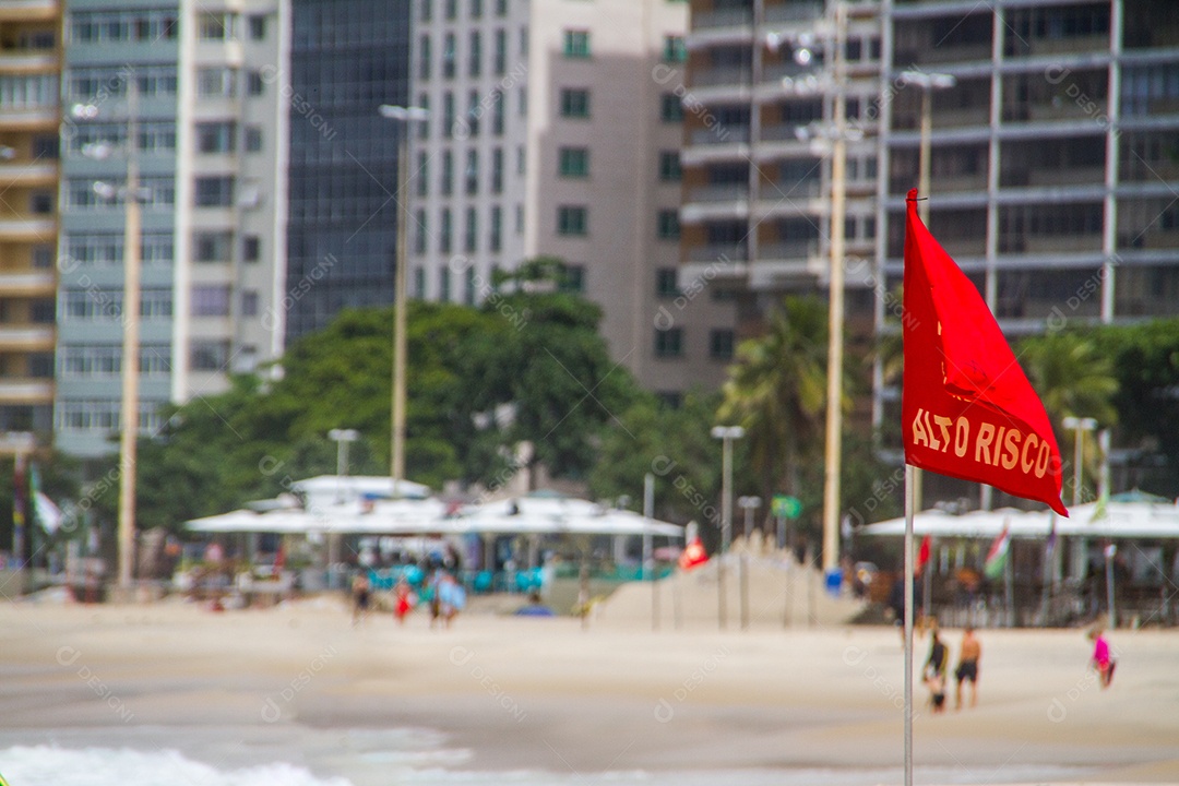 bandeira de sinal vermelho escrito em português alto risco na praia de copacabana no rio de janeiro brasil.