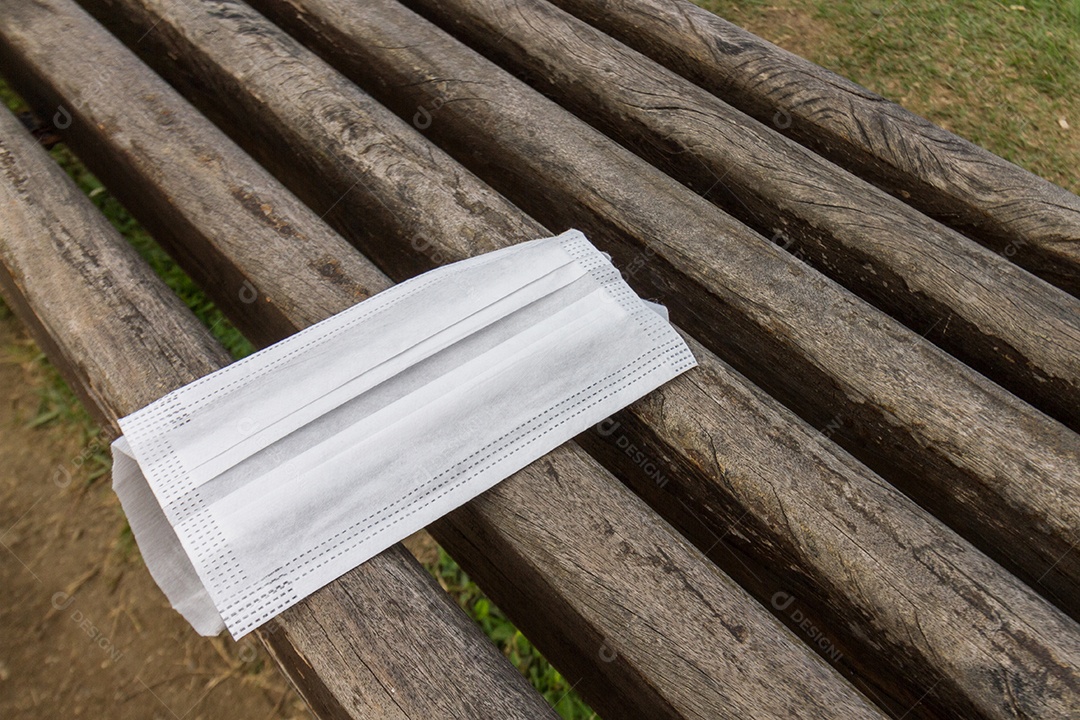 máscara protetora descartada irregularmente sobre um banco público no rio de janeiro, brasil.