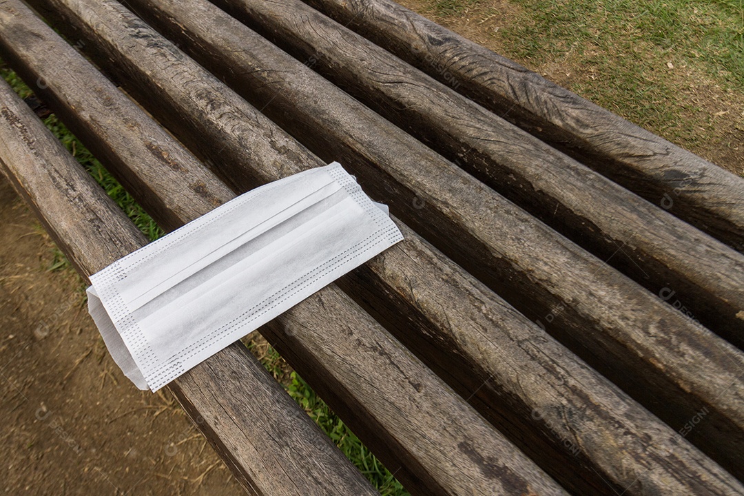 máscara protetora descartada irregularmente sobre um banco público no rio de janeiro, brasil.