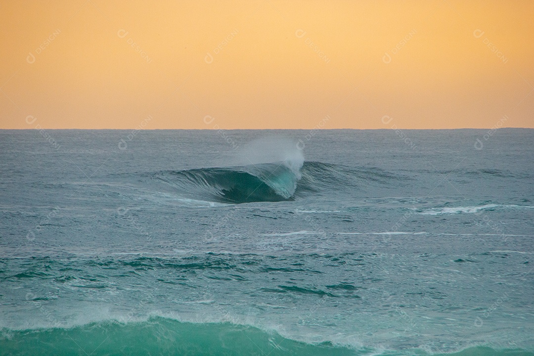 onda secreta na praia de ipanema quebrando solitária com um lindo céu por do sol.