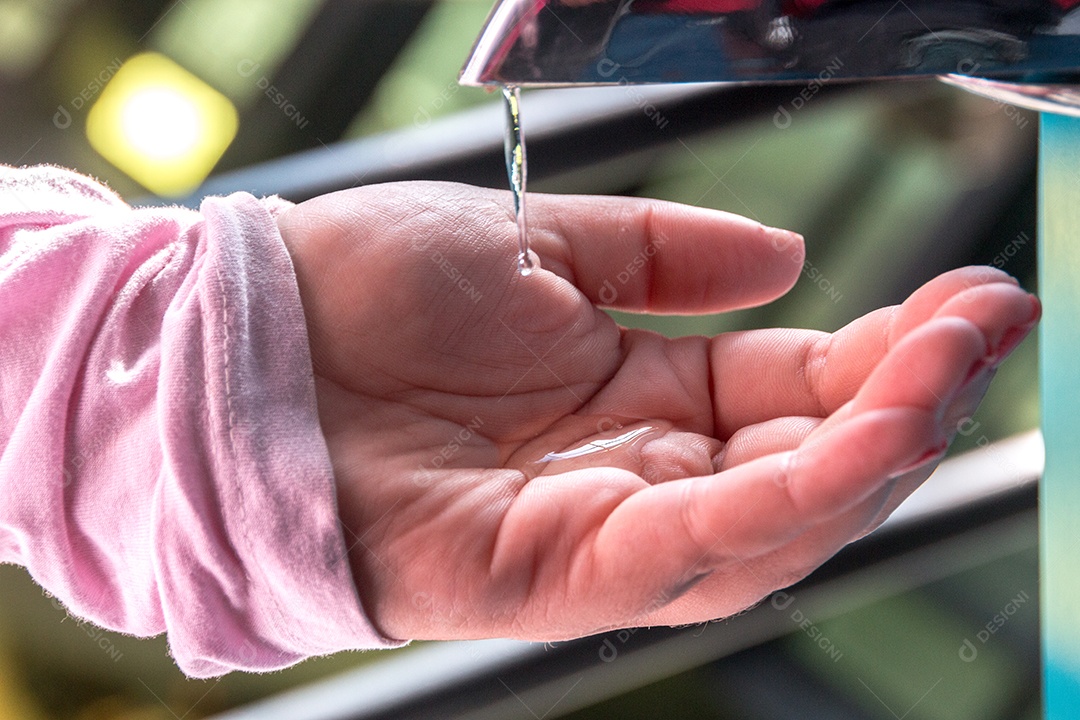 mulher colocando álcool gel na mão no Rio de Janeiro.