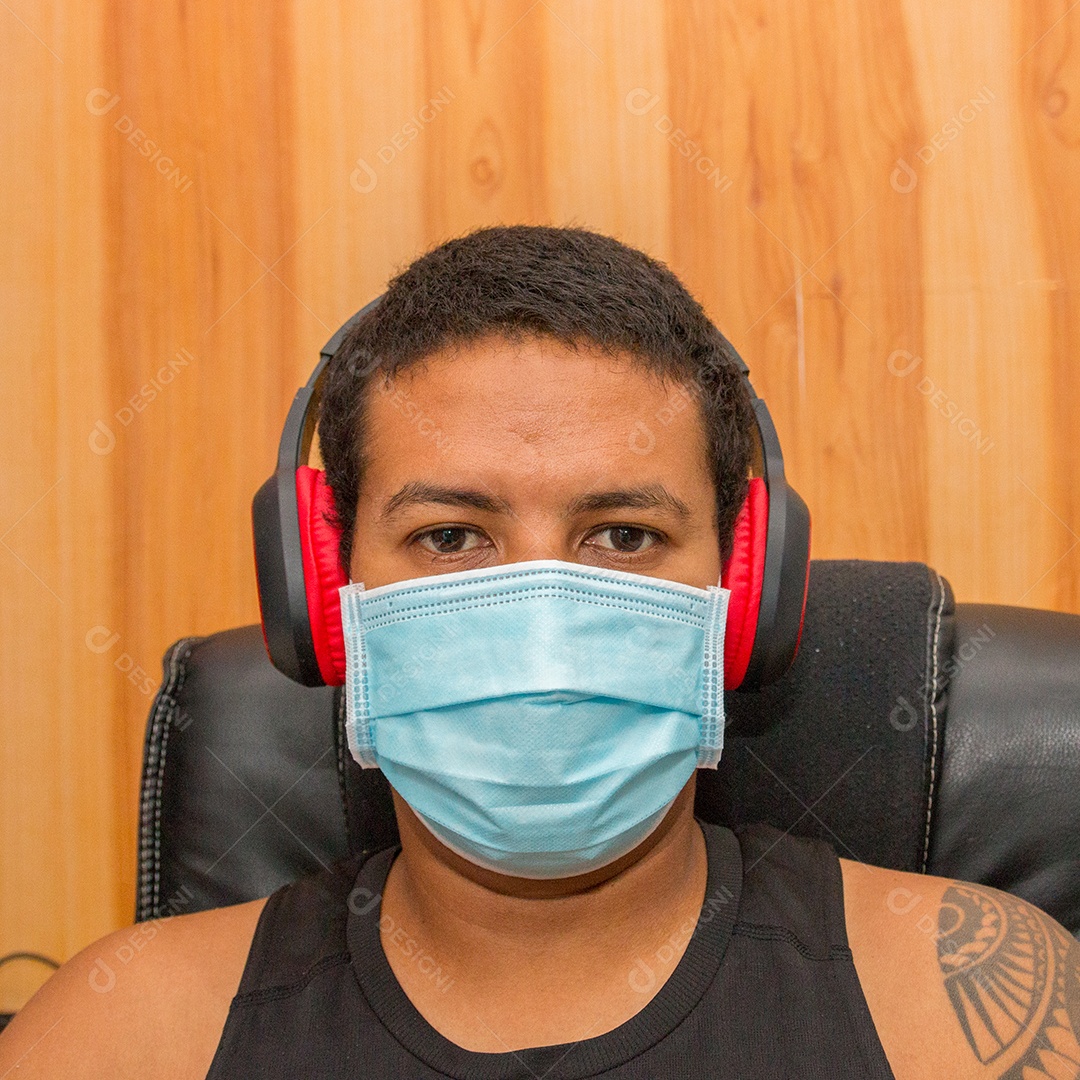 Homem negro com fone de ouvido e máscara protetora azul contra coronavírus no rio de janeiro brasil.