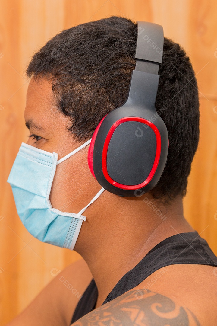 Homem negro com fone de ouvido e máscara protetora azul contra coronavírus no rio de janeiro brasil.