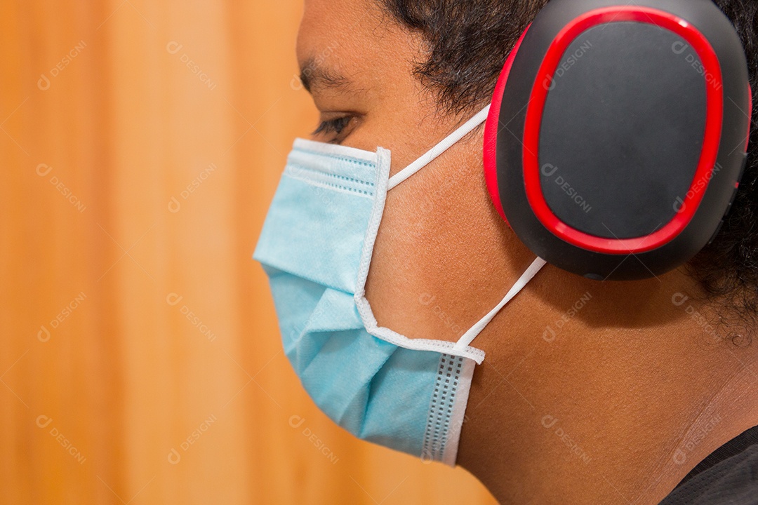 Homem negro com fone de ouvido e máscara protetora azul contra coronavírus no rio de janeiro brasil.
