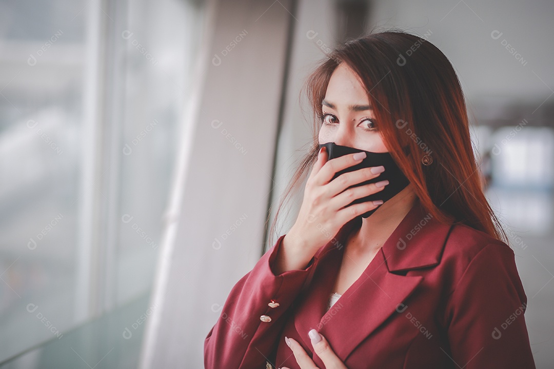 Mulher asiática usando máscara e falando no celular para profissional