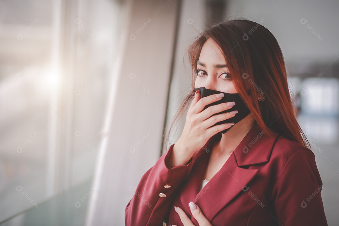 Mulher asiática usando máscara e falando no celular para profissional