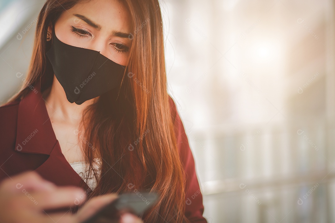 Mulher asiática usando máscara e falando no celular para profissional