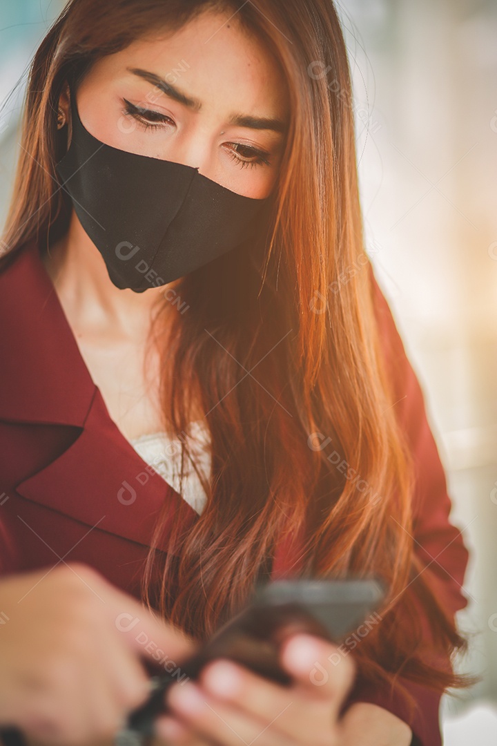 Mulher asiática usando máscara e falando no celular para profissional