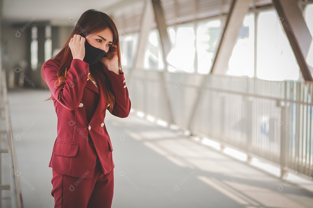 Mulher asiática usando máscara e falando no celular para profissional
