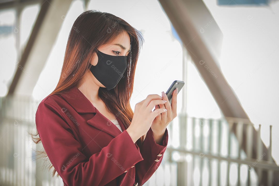 Mulher asiática usando máscara e falando no celular para profissional