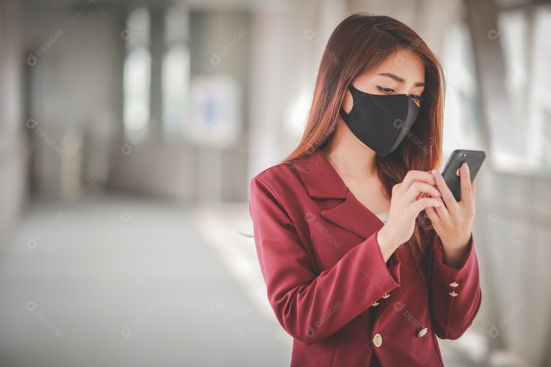 Mulher asiática usando máscara e falando no celular para profissional