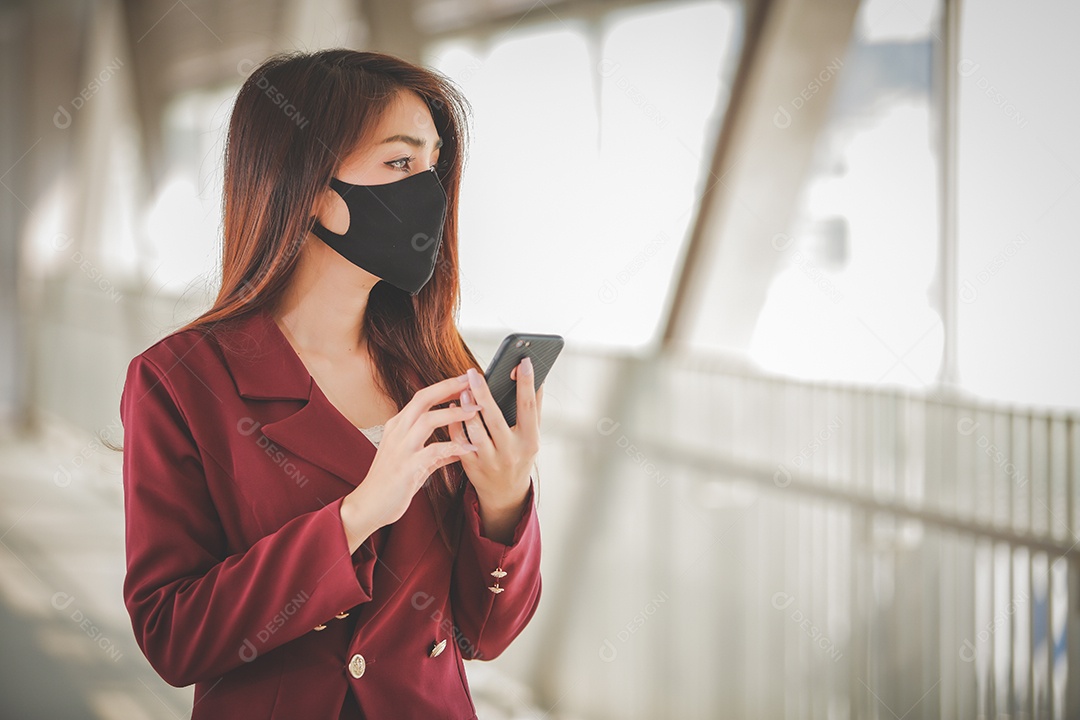 Mulher asiática usando máscara e falando no celular para profissional