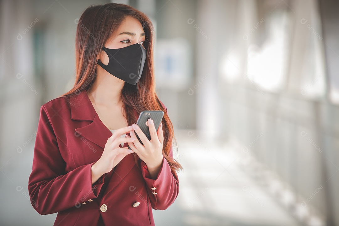 Mulher asiática usando máscara e falando no celular para profissional