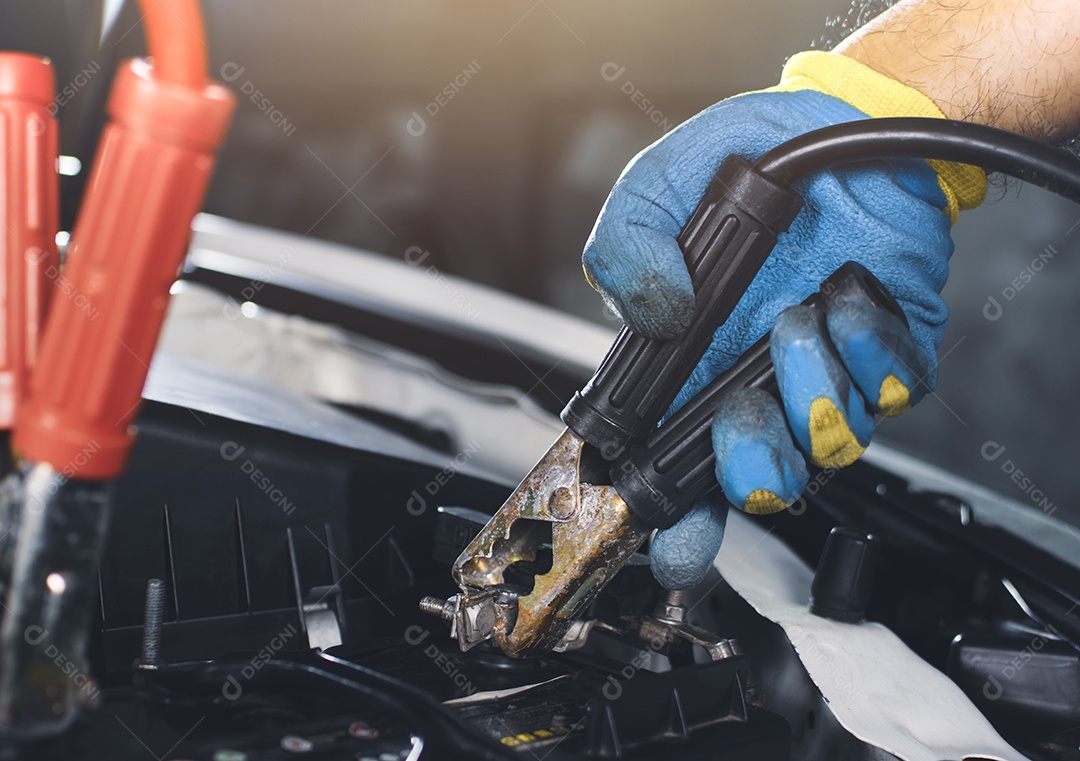Técnico prendendo o jumper dos fios do cátodo à bateria do carro