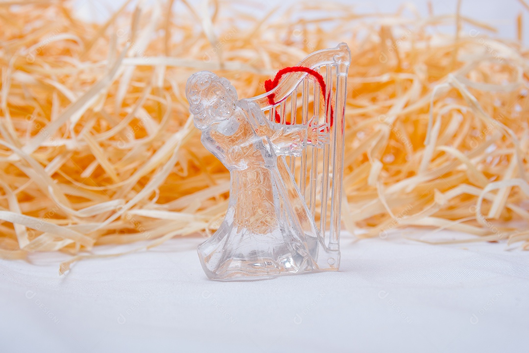 anjo transparente para decoração de Natal em um fundo de palha no Rio de Janeiro.