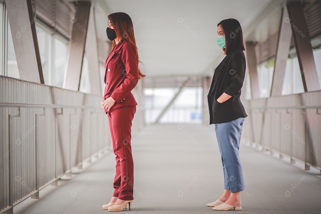 Duas mulheres asiáticas a uma distância de 1 metro de outras pessoas mantêm distância protegem contra vírus COVID-19 e distanciamento social de pessoas para risco de infecção.