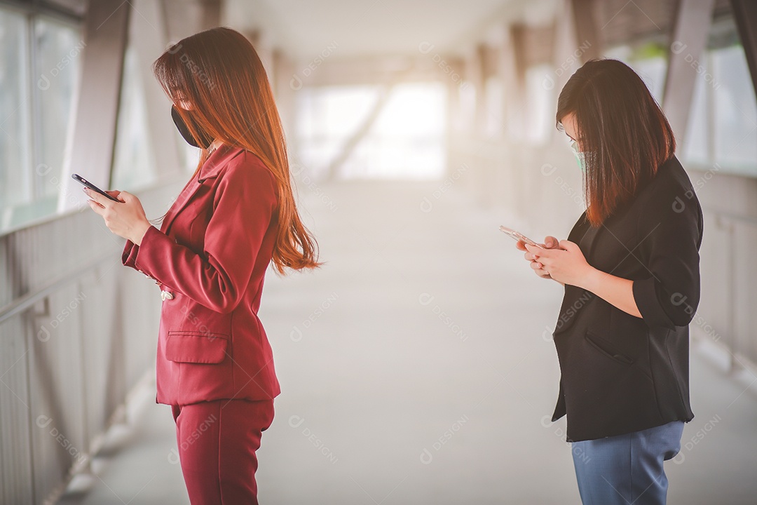 Duas mulheres asiáticas a uma distância de 1 metro de outras pessoas mantêm distância protegem contra vírus COVID-19 e distanciamento social de pessoas para risco de infecção.