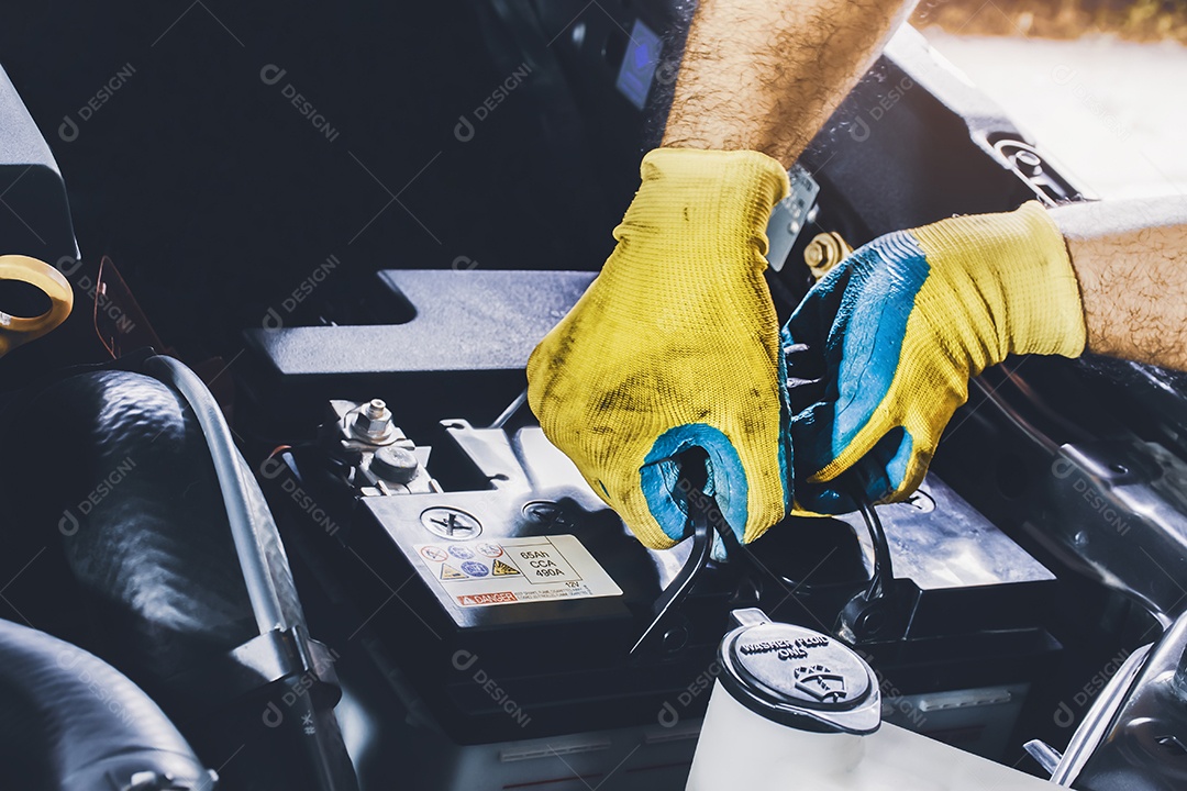 O mecânico tirou a bateria do carro velho da comparação do motor