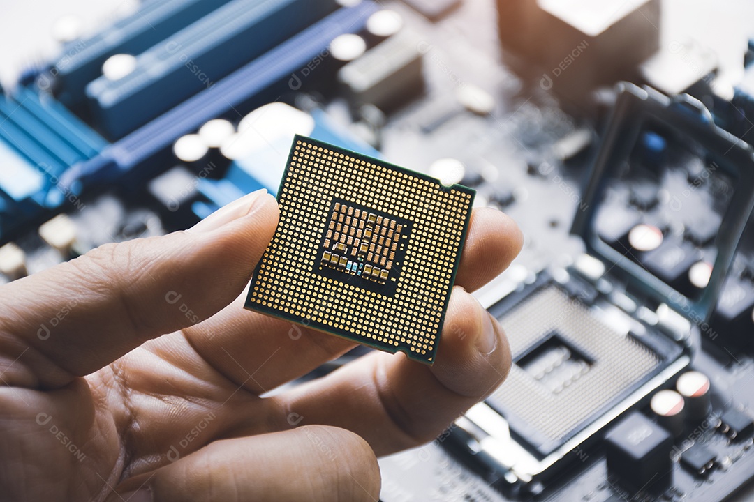 Chip de processador da CPU na mão do técnico e na placa-mãe do computador