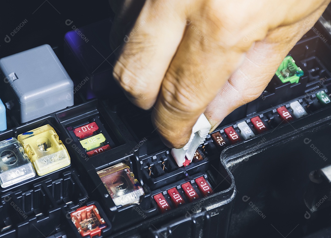 O mecânico substitui o fusível sobressalente na caixa de fusíveis do carro