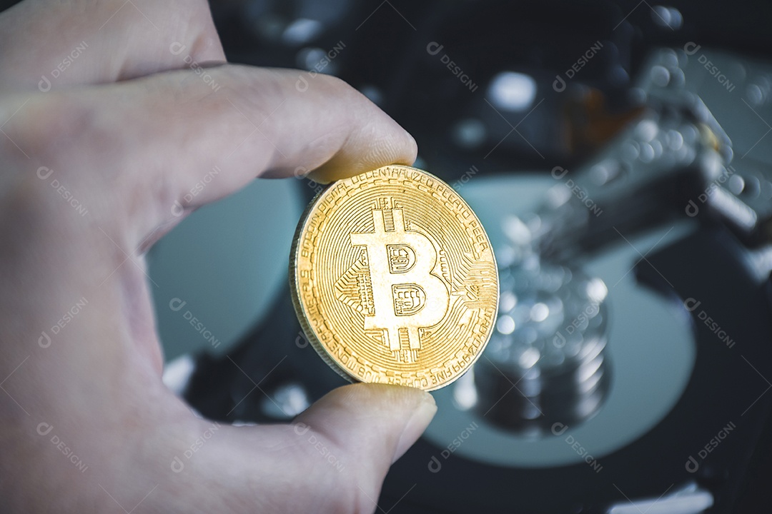 Close-up de ouro bitcoin na mão com pratos de disco rígido