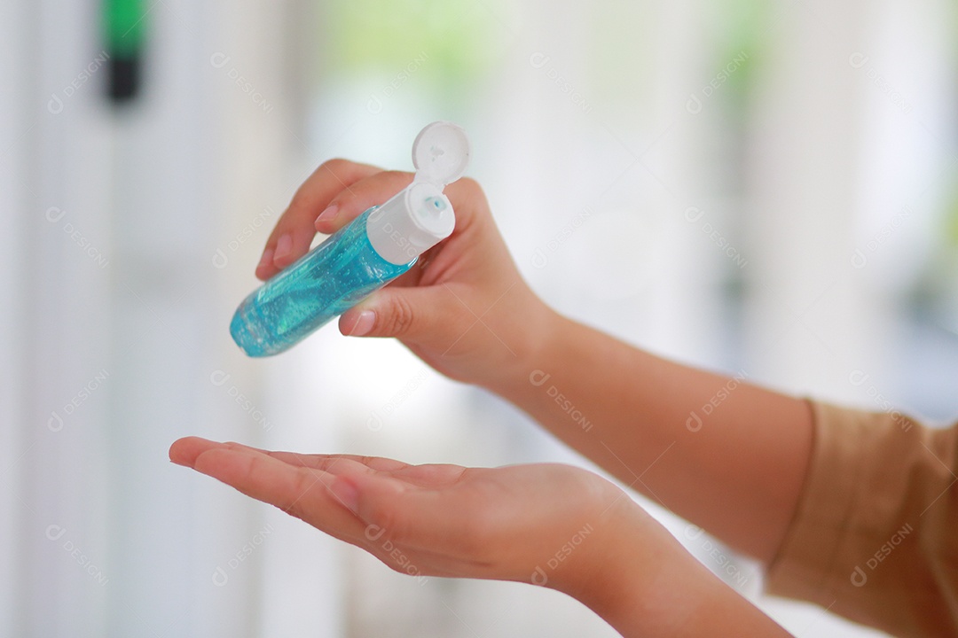 Mulher que desinfeta a pele com desinfetante para as mãos previne a infecção