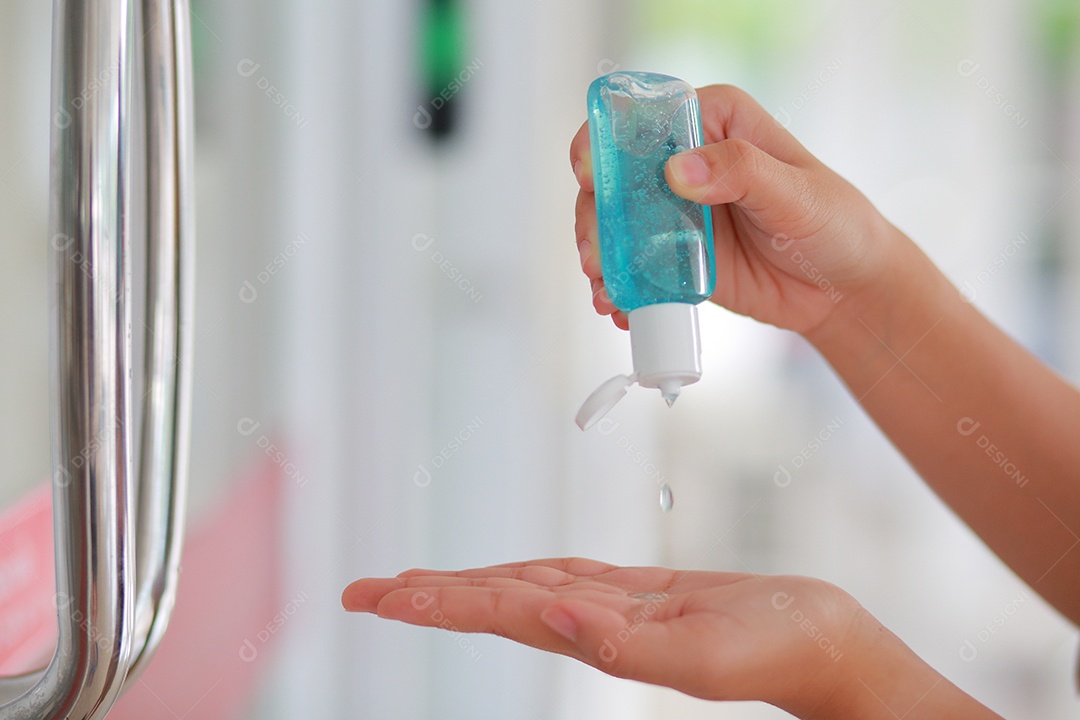 Mulher que desinfeta a pele com desinfetante para as mãos previne a infecção