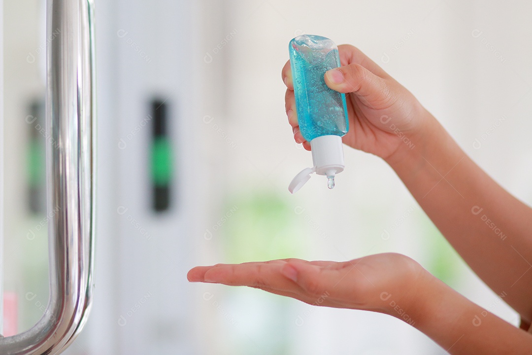 Mulher que desinfeta a pele com desinfetante para as mãos previne a infecção