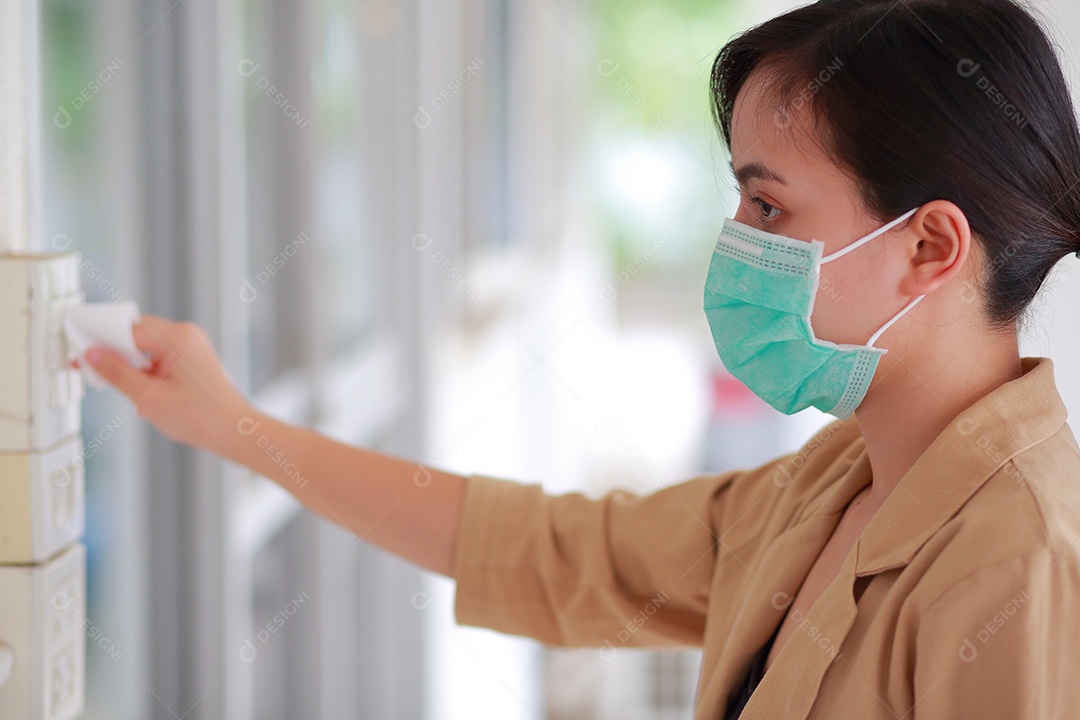 Mulher está tocando um interruptor de luz para acender as luzes
