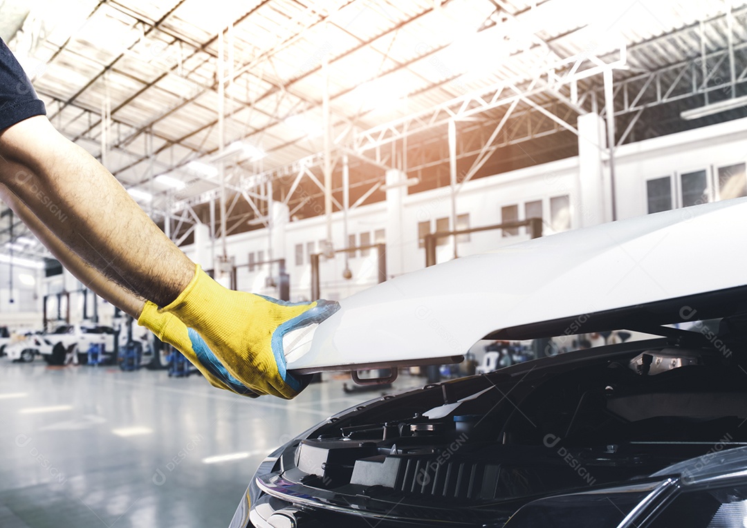 Mão do técnico puxando o capô do carro para manutenção no reparo